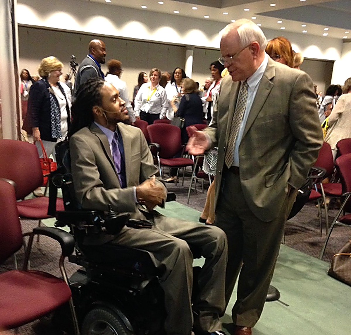Que Crane connecting with a leader at a conference